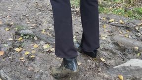 A girl in ankle boots tries to climb a mud mountain, but she always slips off, her heels get dirty and she slides down (reissue)