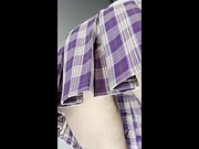 Thighs pressed tight under a lifted plaid skirt