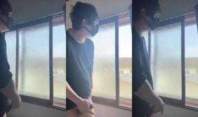 Sneaky twink jerks off by window drenched in thick white cum