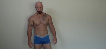 Tattooed and bald stud with beard playing with his