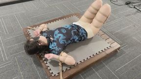 A young woman in a cheongsam, her flesh-colored stockings, was fixed to a wooden board